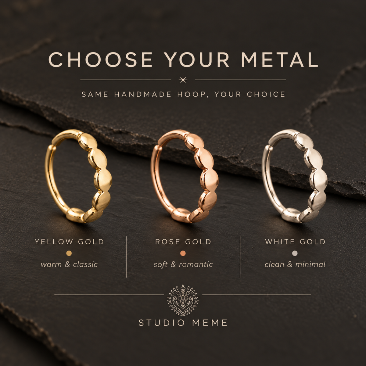 three rings with different colored metal hangers, each with a unique design, arranged on a dark surface.