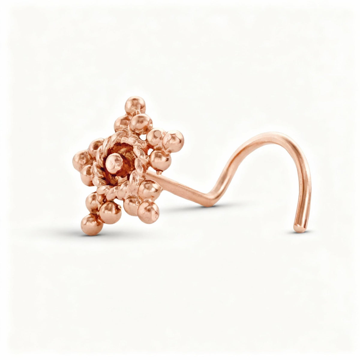 A rose gold-colored nose ring with a twisted, ornate design.
