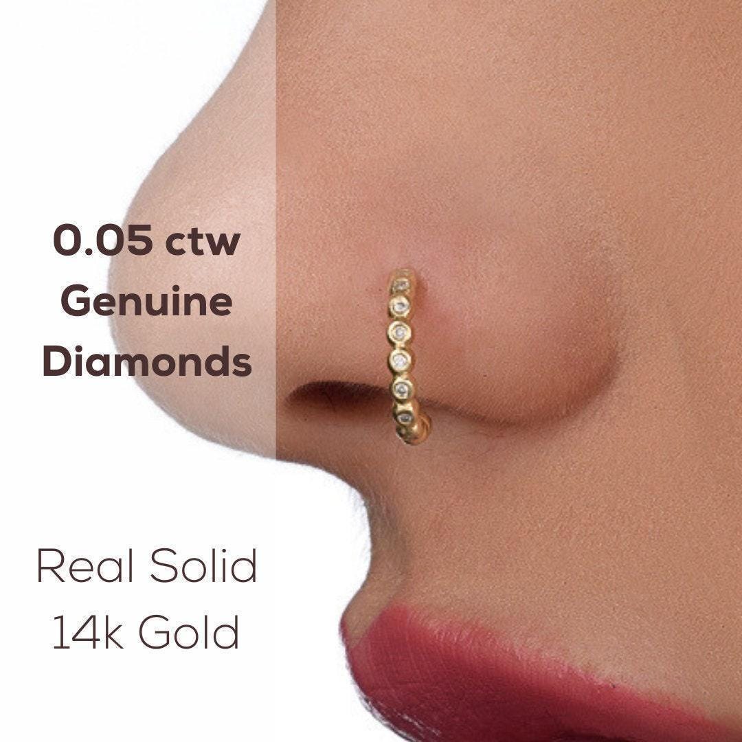 Diamond Nose Ring: a close-up of a person's nose with a gold nose ring adorned with small diamonds.