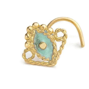 A gold-colored nose ring with a turquoise stone in the center, surrounded by a decorative gold frame.
