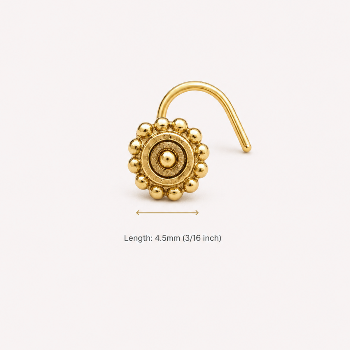 A gold-colored nose stud with a decorative flower-like design on it.