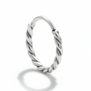 Nose Ring: A silver ring with a twisted design sits on a rock.