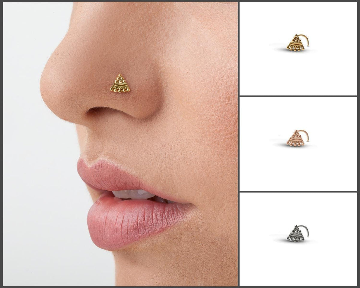 A close-up of a person's face, focusing on their nose and lips. There are four different nose and lip piercings displayed in various colors and designs.