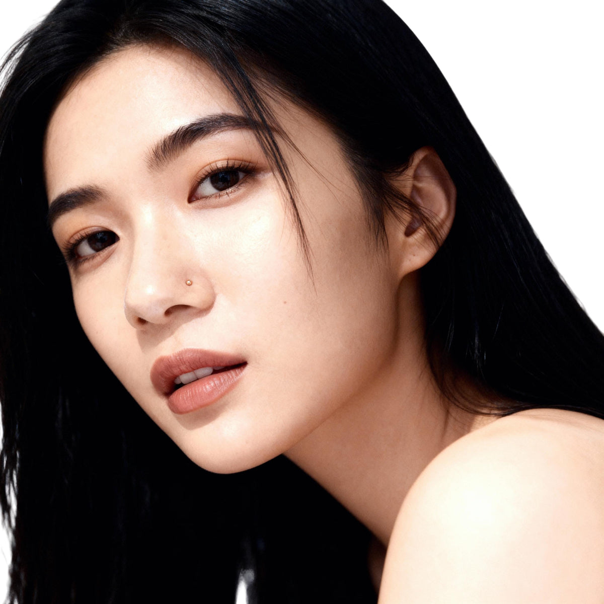 A close-up portrait of a young Asian woman with long dark hair, looking directly at the camera with a neutral expression.
