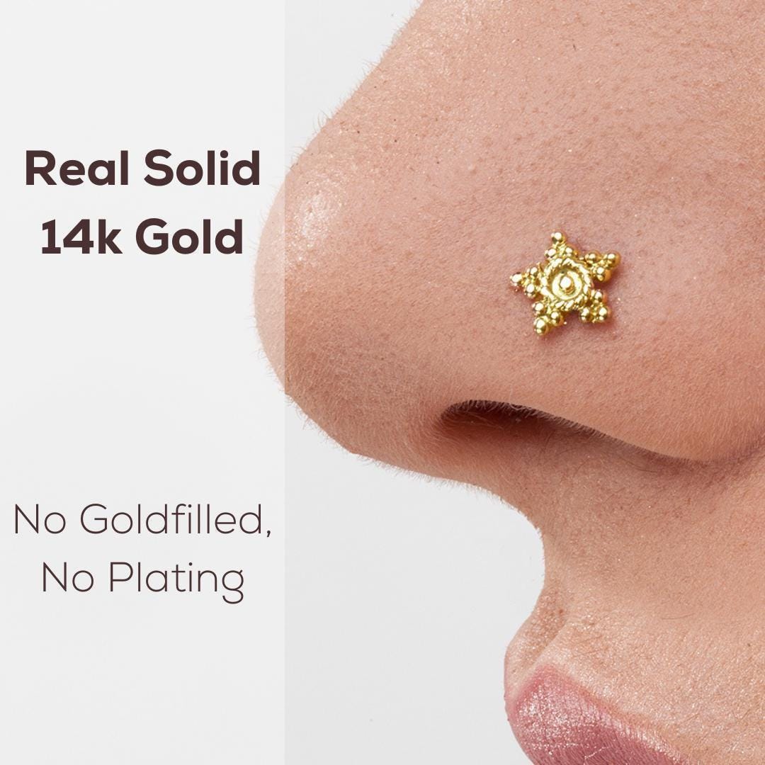 a close-up of a person's nose with a gold-colored nose stud or piercing.