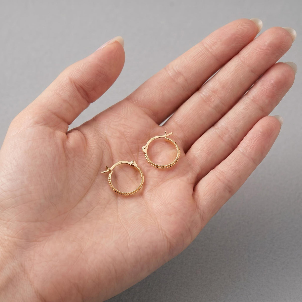 14k gold hoops on a woman's hand