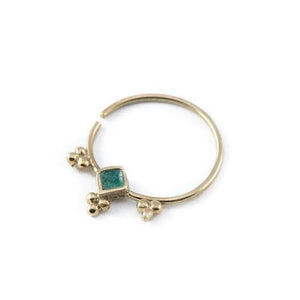 Dainty Gold Nose Ring: A gold-colored nose ring with a green gemstone in the center.