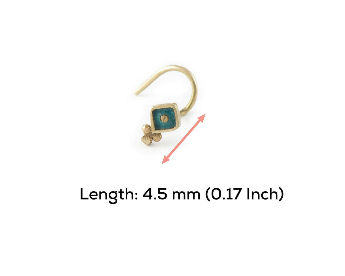 A gold-colored nose stud with a blue gemstone is shown against a white background.