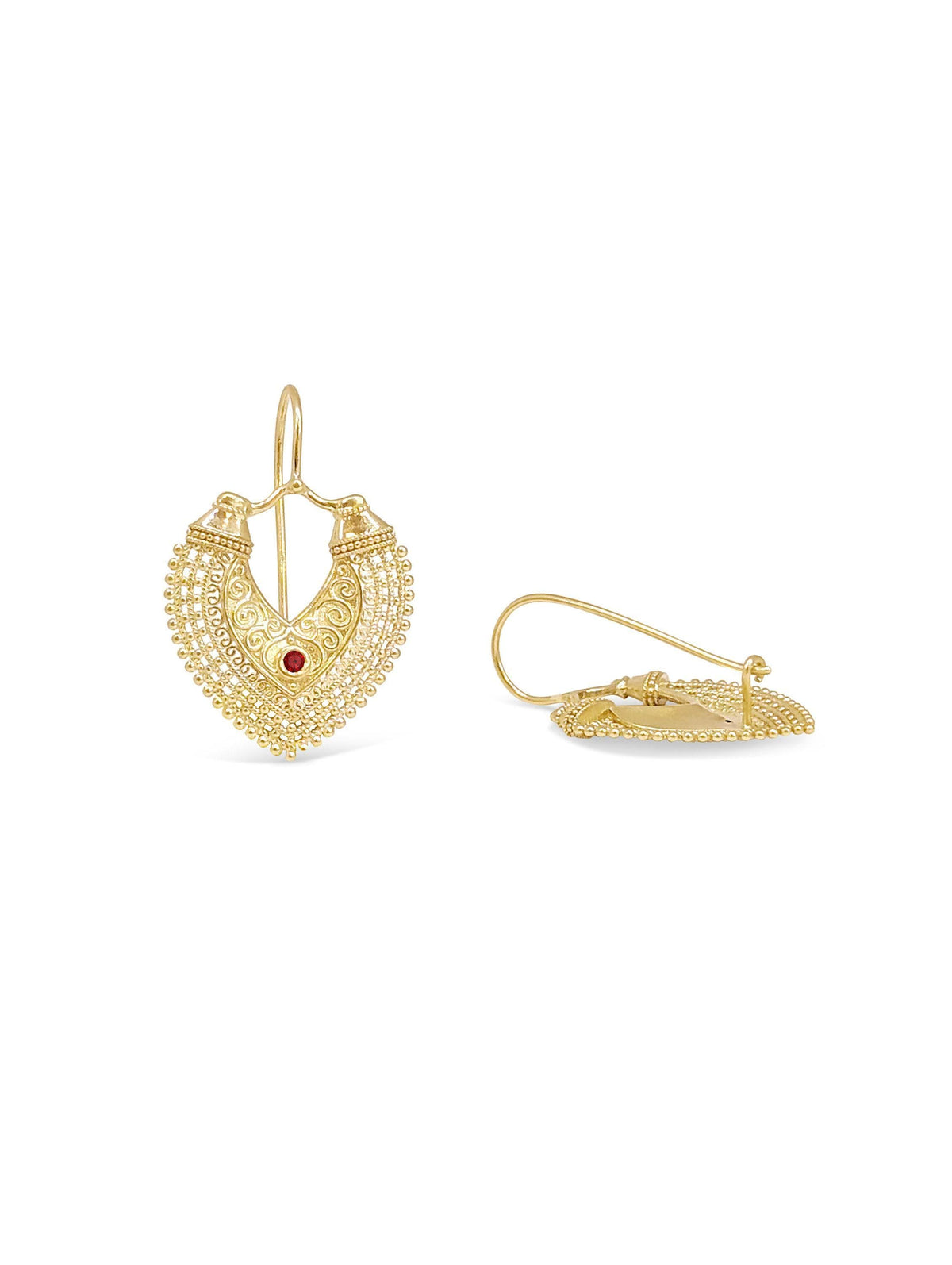 a pair of gold earrings with intricate designs and a red gemstone.