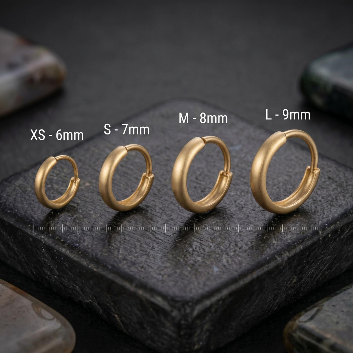 four gold earrings of different sizes, each labeled with its corresponding size in millimeters: XS-6mm, S-7mm, M-8mm, and L-9mm.