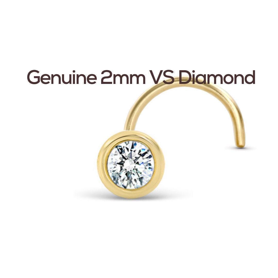a gold nose ring with a clear gemstone, specifically a diamond, set in the center.