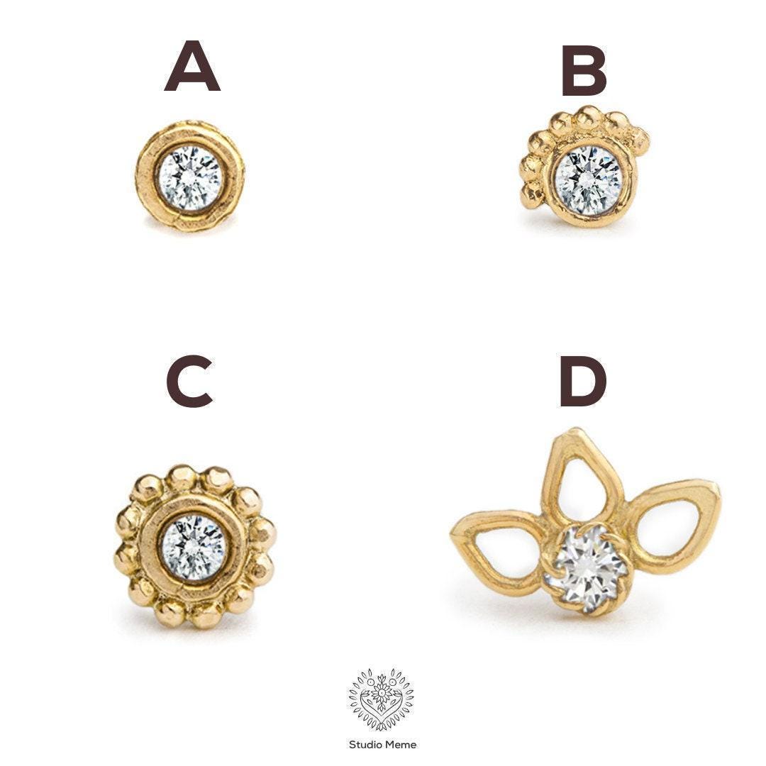 Four different gold-colored earrings, each with a clear gemstone set in the center. The earrings are arranged in a grid-like pattern, with each pair displayed in a separate image.