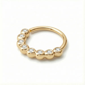 A gold ring with a curved band and small diamonds set in it.