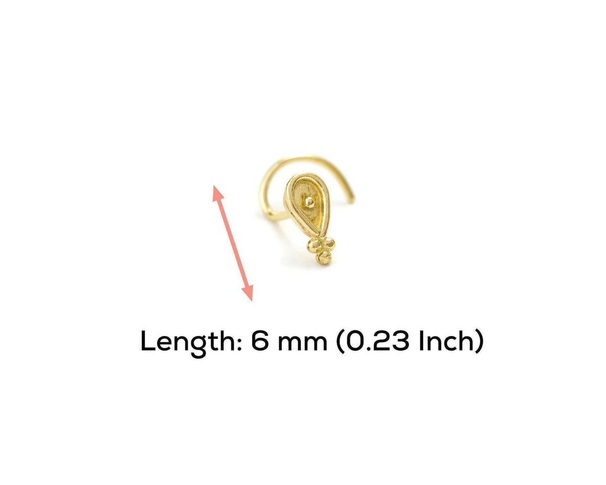 A gold-colored nose ring with a small decorative element is shown against a white background.