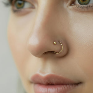 Solid Gold Nose Ring and Stud Set: A close-up of a person's face, focusing on their nose and lips.