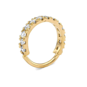 A gold ring with a curved band and a row of small diamonds along the top edge.