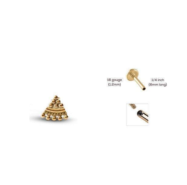 three gold-colored objects, including a small golden triangle-shaped object, a gold-colored metal tube, and a gold-colored metal connector.