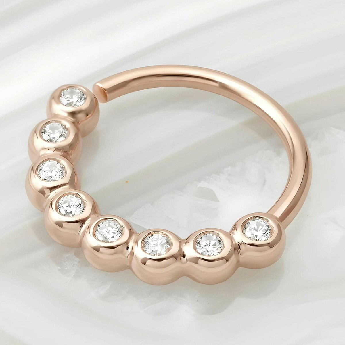 A unique nose ring in solid 14k rose gold and neturl diamonds