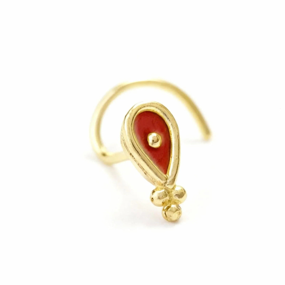 A gold-colored nose ring with a red gemstone in the center.