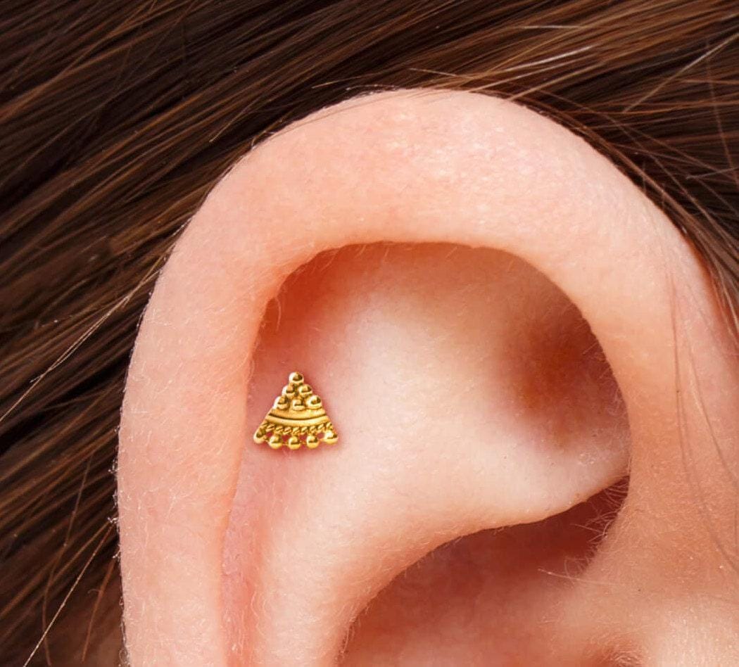 A small gold-colored earring is visible in the ear.