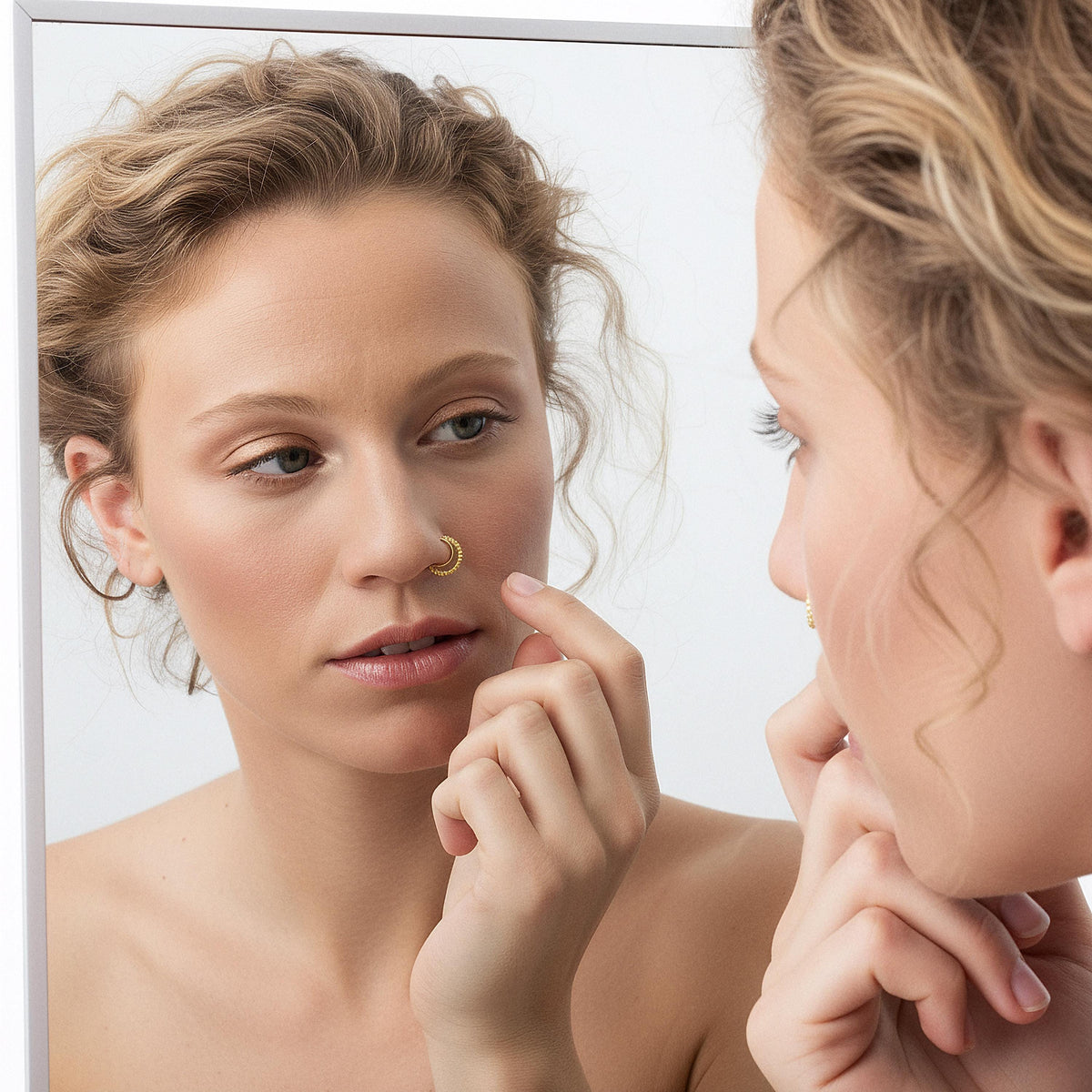 A woman with curly hair is seen in front of a mirror, examining her nose with her finger.