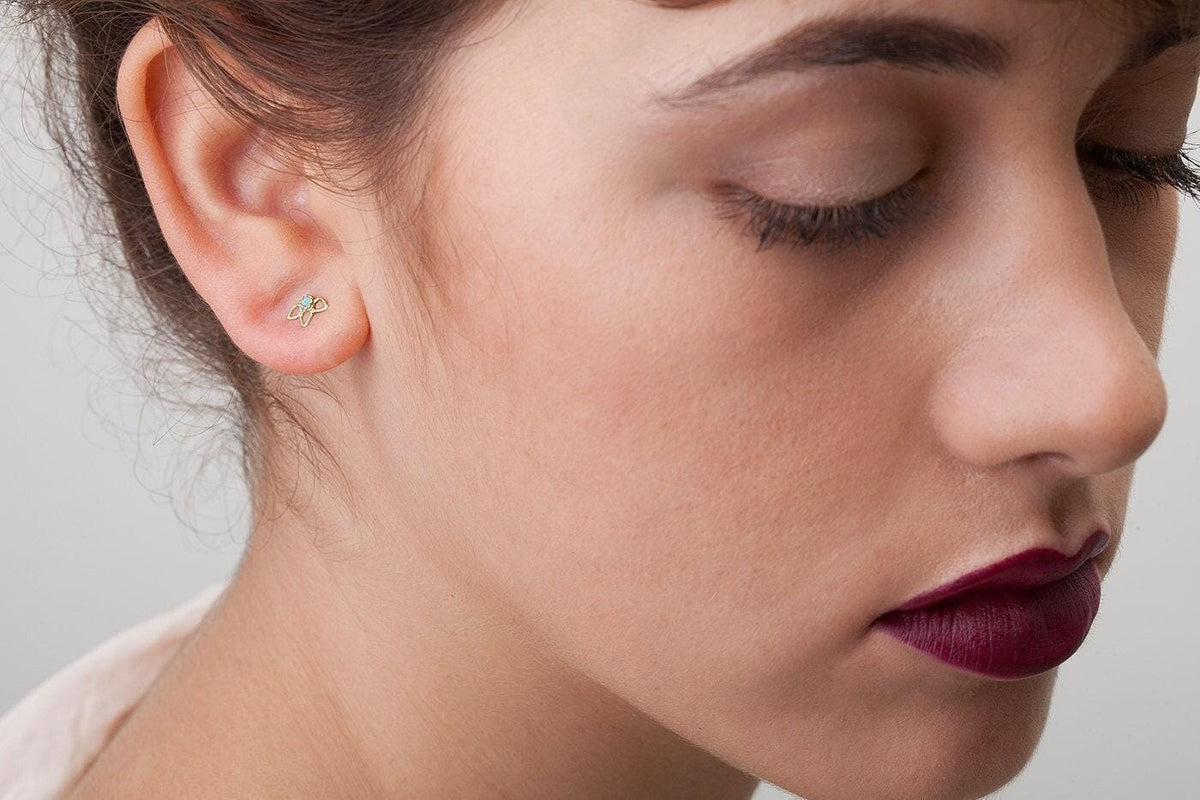 A close-up of a woman's face, focusing on her earrings and lips.