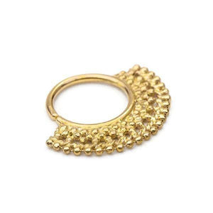 A gold-colored metal nose ring with a decorative, textured design.